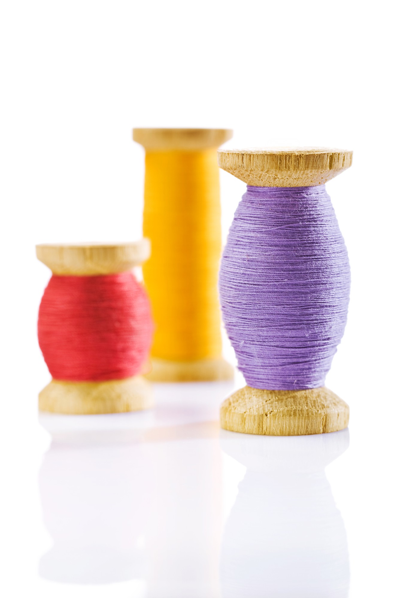 Close-up colorful threads on wooden spool